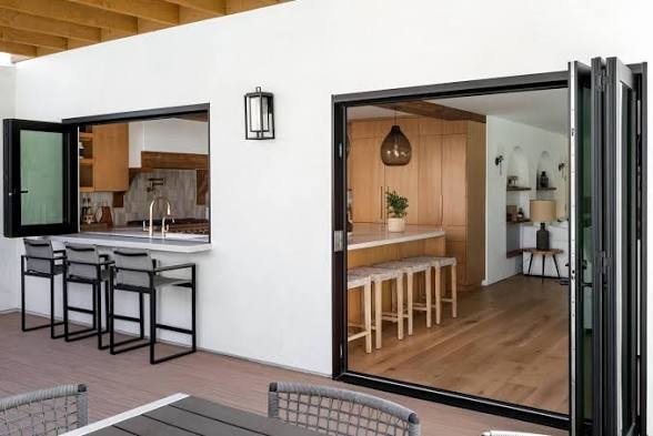 Modern outdoor living space with Windor folding doors and kitchen pass-through window